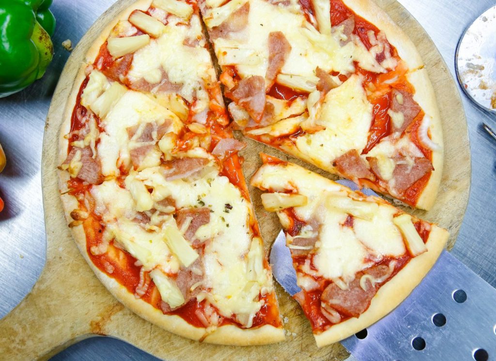 pizza sur une assiette ronde en bois brun