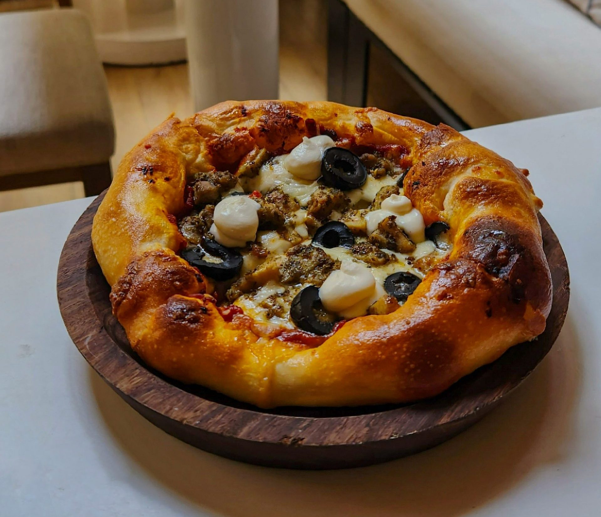 une pizza posée sur une assiette en bois sur une table