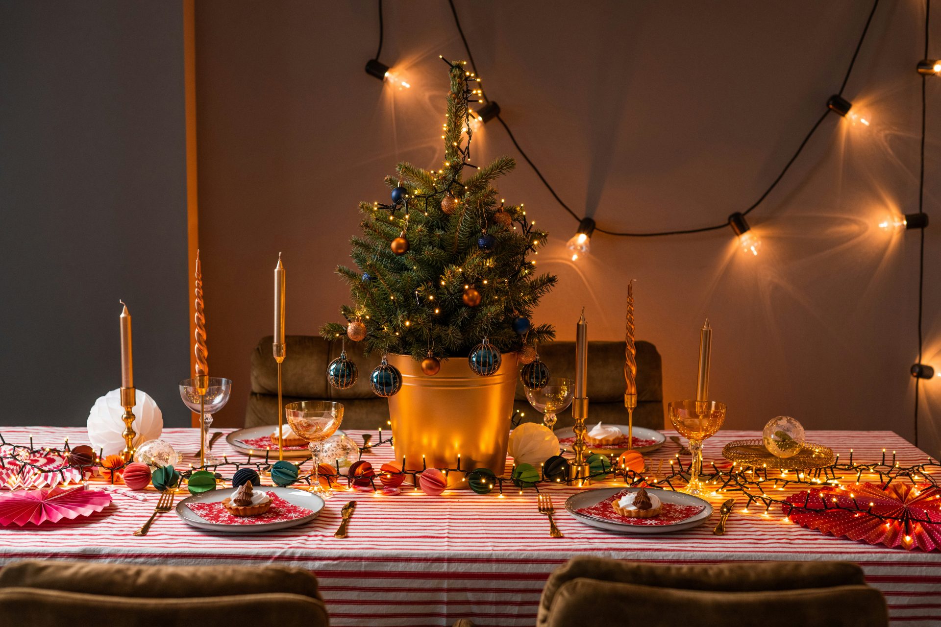 une table avec un sapin de Noël et des assiettes et des verres dessus